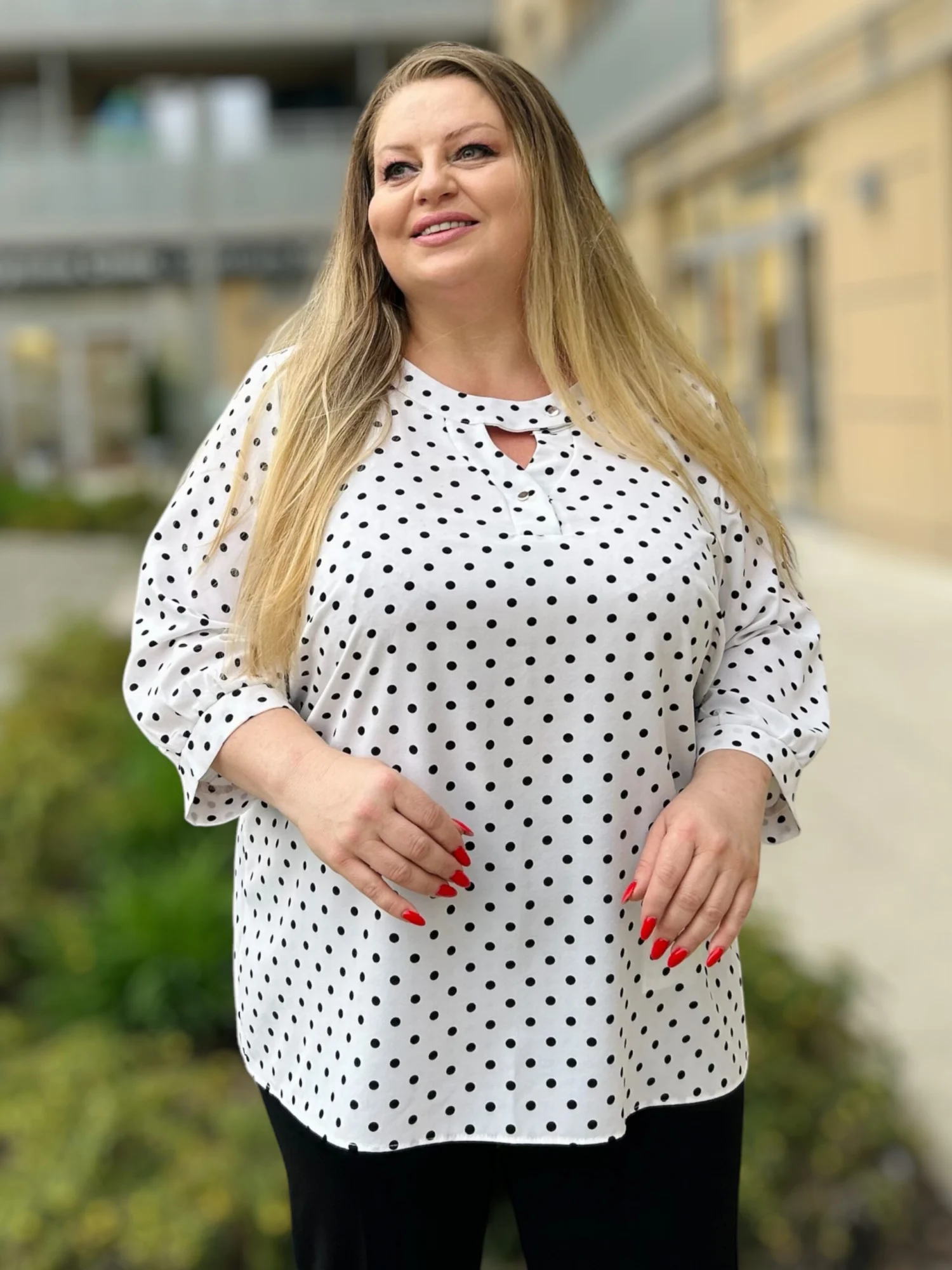 Bluzka damska Irena, widok z przodu, z bliska, prezentujący dekolt z wycięciem i wzór w czarne grochy.