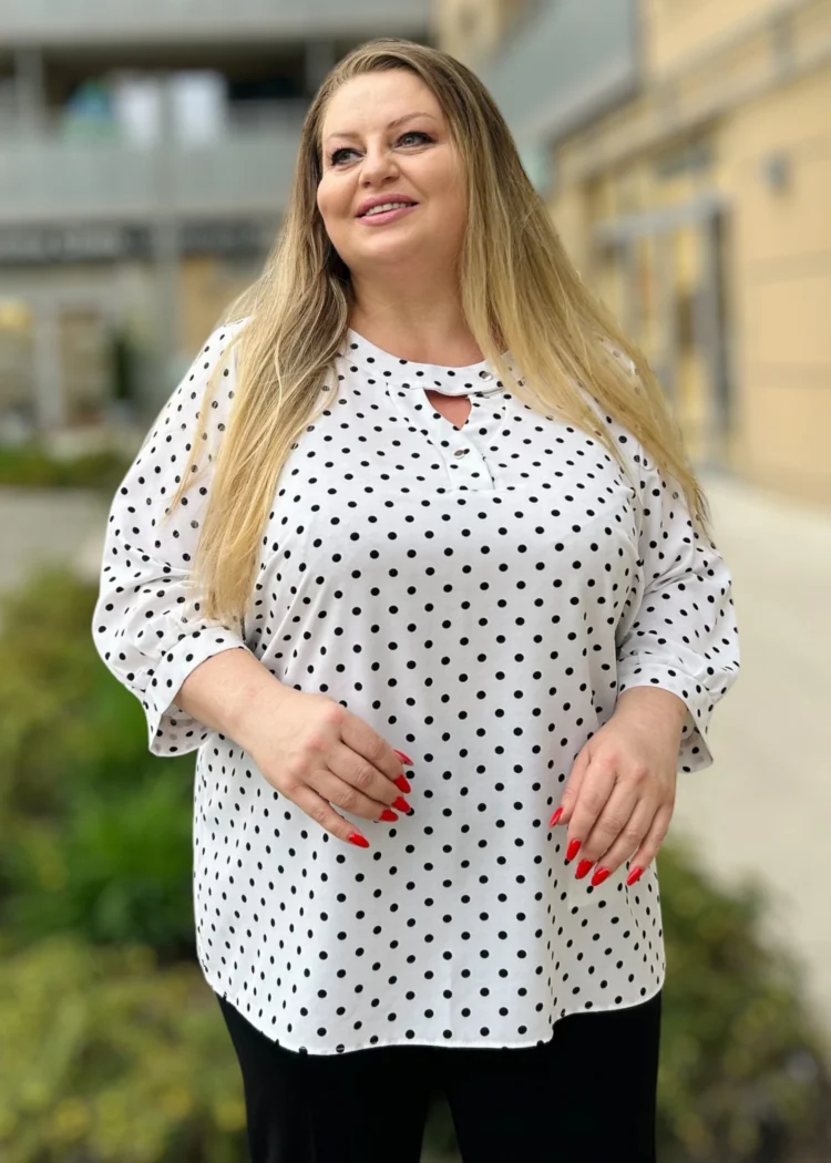 Bluzka damska Irena, widok z przodu, z bliska, prezentujący dekolt z wycięciem i wzór w czarne grochy.