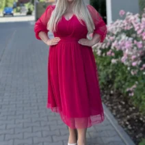 Sukienka damska Dagmara: widok z przodu z rękami na biodrach, ukazujący dopasowanie w talii.