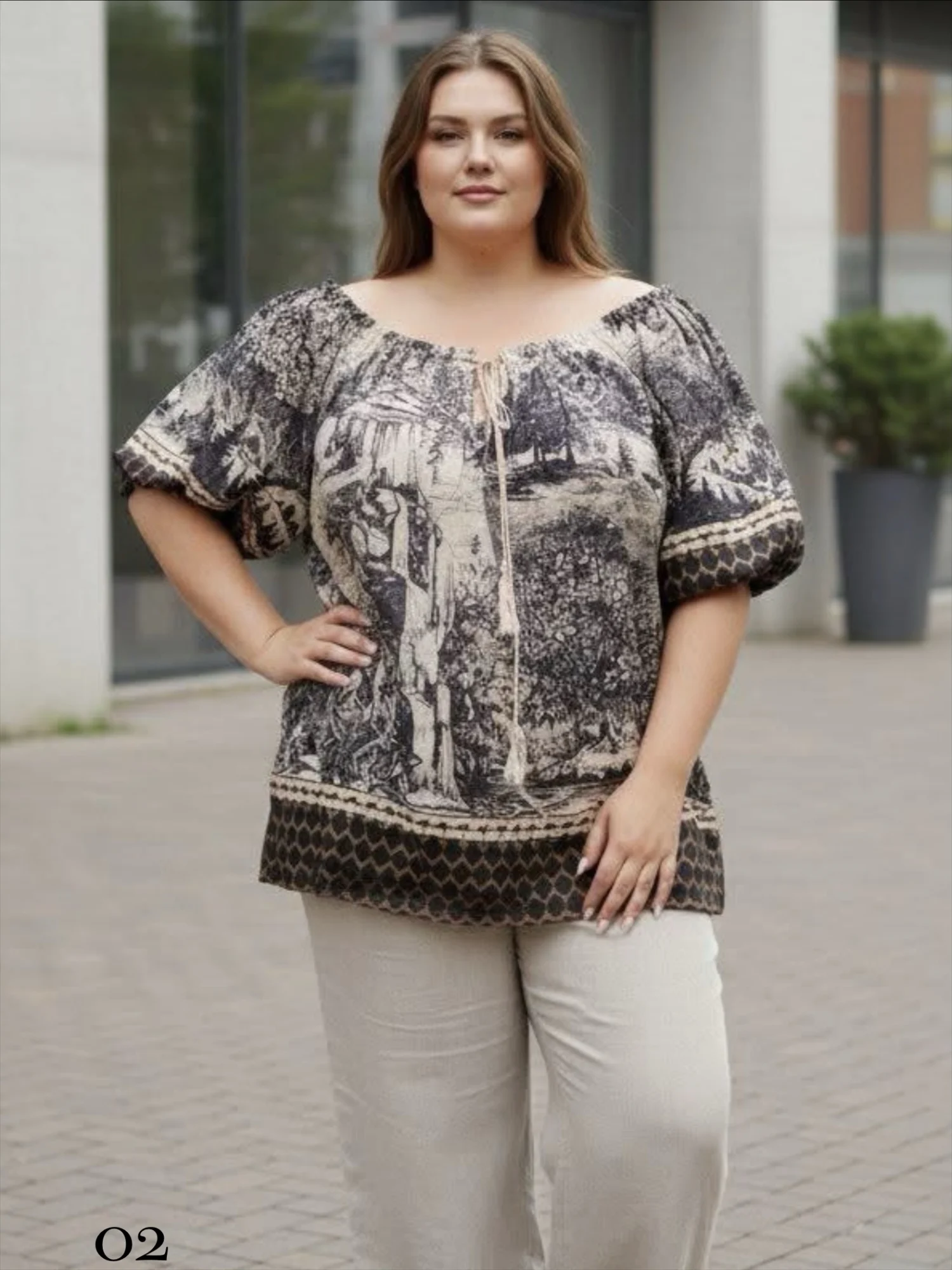 Bluzka damska Nadia, pełny przód, beżowa z czarnym wzorem, ukazująca luźny fason i długość.