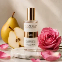 Perfumy Yodeyma Lido, butelka z przodu, widoczna etykieta i złoty korek, otoczona gruszkami i różowymi