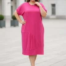Sukienka damska Alma: ujęcie z przodu, ukazujące swobodny układ materiału i detale fasonu w ruchu.