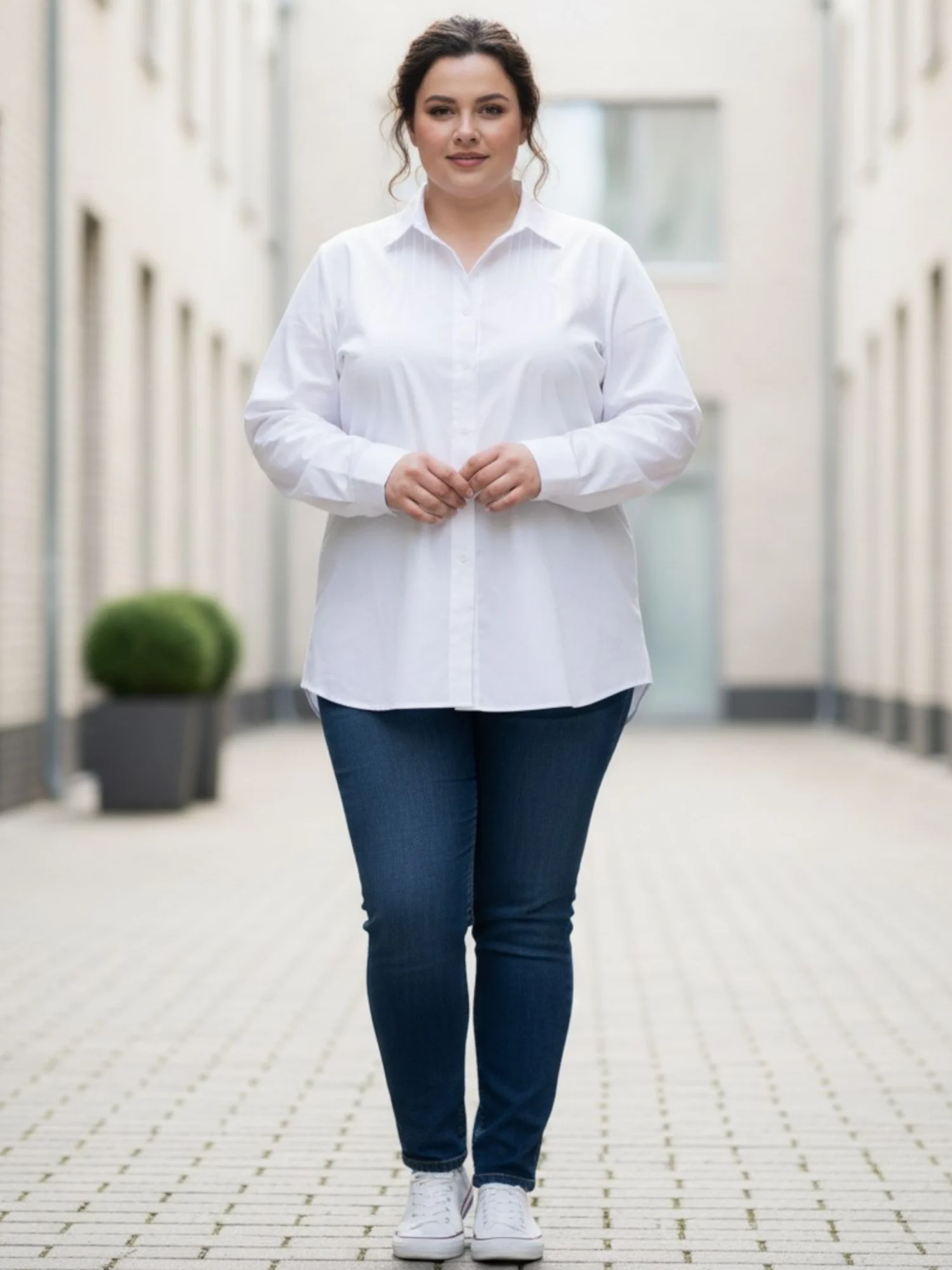 koszula_biala_waleria_plus_size_dlugi_rekaw Koszula damska Waleria. Biała koszula z przodu, ukazująca długość i swobodny krój w połączeniu z jeansami.