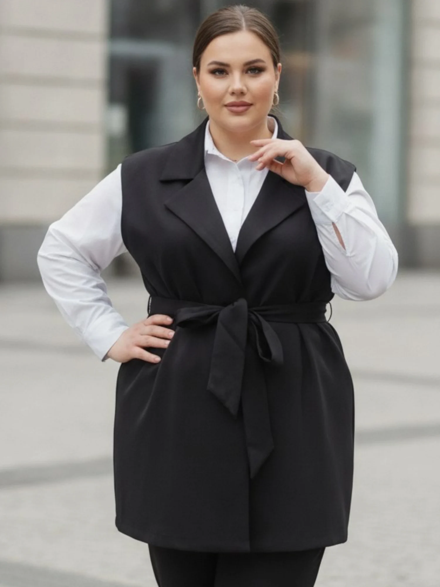 Kamizelka damska Weronika: zbliżenie na przód kamizelki z eleganckimi klapami i wiązanym paskiem.