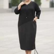 Sukienka damska Adelina, ujęcie z przodu z dłonią w kieszeni, podkreślające praktyczne detale.