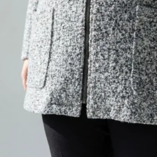 Kurtka z bukli z kapturem i kieszeniami: zbliżenie na kieszeń i dolny brzeg.