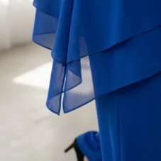Spodnie damskie Komplet damski wizytowy: detal lejącego się materiału bluzki i nogawki spodni.
