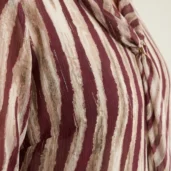 Bluzka damska Elegancka bordowo-beżowa bluzka, ujęcie z boku, eksponujące wzór i detal krawata.