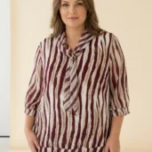 Bluzka damska Elegancka bordowo-beżowa bluzka, ujęcie z przodu, z wyraźnym biżuteryjnym detalem.