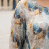 Bluzka damska Elegancka bluzka plus size w niebiesko-złoty wzór, zbliżenie na dekolt i wzór materiału.