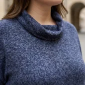 Sweter damski Granatowa bluzka sweterkowa, zbliżenie na luźny golf i melanżową fakturę materiału.