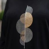 Bluzka z motywem geometrycznych kół: detal geometrycznego wzoru z kołami i liniami w odcieniach złota i