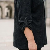 Sweter damski XXL zapinany na guzik, zbliżenie na podwinięty rękaw z patką i guzikiem.