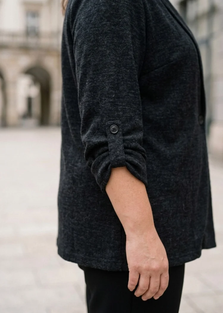 Sweter damski XXL zapinany na guzik, zbliżenie na podwinięty rękaw z patką i guzikiem.