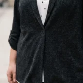 Sweter damski XXL zapinany na guzik, detal zapięcia na guzik i eleganckiego kołnierza z klapami.