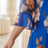Zwiewna szyfonowa sukienka z falbanami na dole, detal rękawa 3/4 z rozkloszowanym zakończeniem.