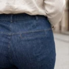 Spodnie jeansowe XXL damskie dzwony, zbliżenie na tylne kieszenie i kontrastowe przeszycia.
