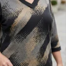 Tunika dzianinowa we wzory: Widok na dekolt w serek i górną część tuniki damskiej z wyrazistym wzorem.