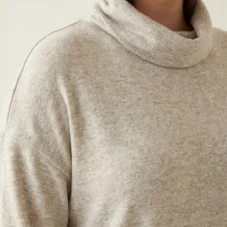 Sweter damski Ciepły beżowy sweter plus size, zbliżenie na miękki golf i obniżoną linię ramion.