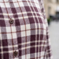 Koszula damska plus size w kratę: zbliżenie na guziki i detal wzoru materiału.