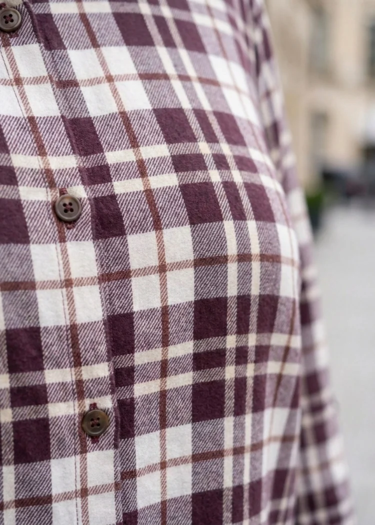 Koszula damska plus size w kratę: zbliżenie na guziki i detal wzoru materiału.