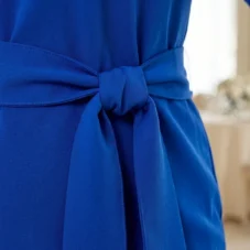 Chabrowa wizytowa sukienka XXL: detal wiązanego paska w talii, zawiązanego na elegancką kokardę.