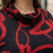 Czarno-czerwona codzienna sukienka w dużych rozmiarach, zbliżenie na dekolt komin i czerwony wzór.