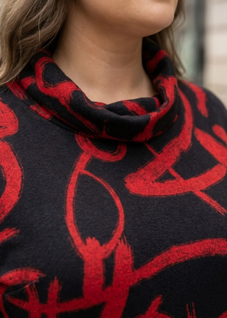 Czarno-czerwona codzienna sukienka w dużych rozmiarach, zbliżenie na dekolt komin i czerwony wzór.