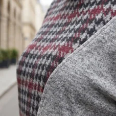 Sweter damski Bluzka sweterkowa z kominem w pepitkę, detal wzoru pepitki i szarego materiału.
