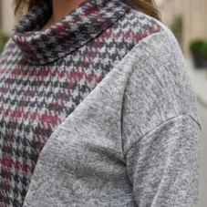 Sweter damski Bluzka sweterkowa z kominem w pepitkę, zbliżenie na dekolt i połączenie wzorów.
