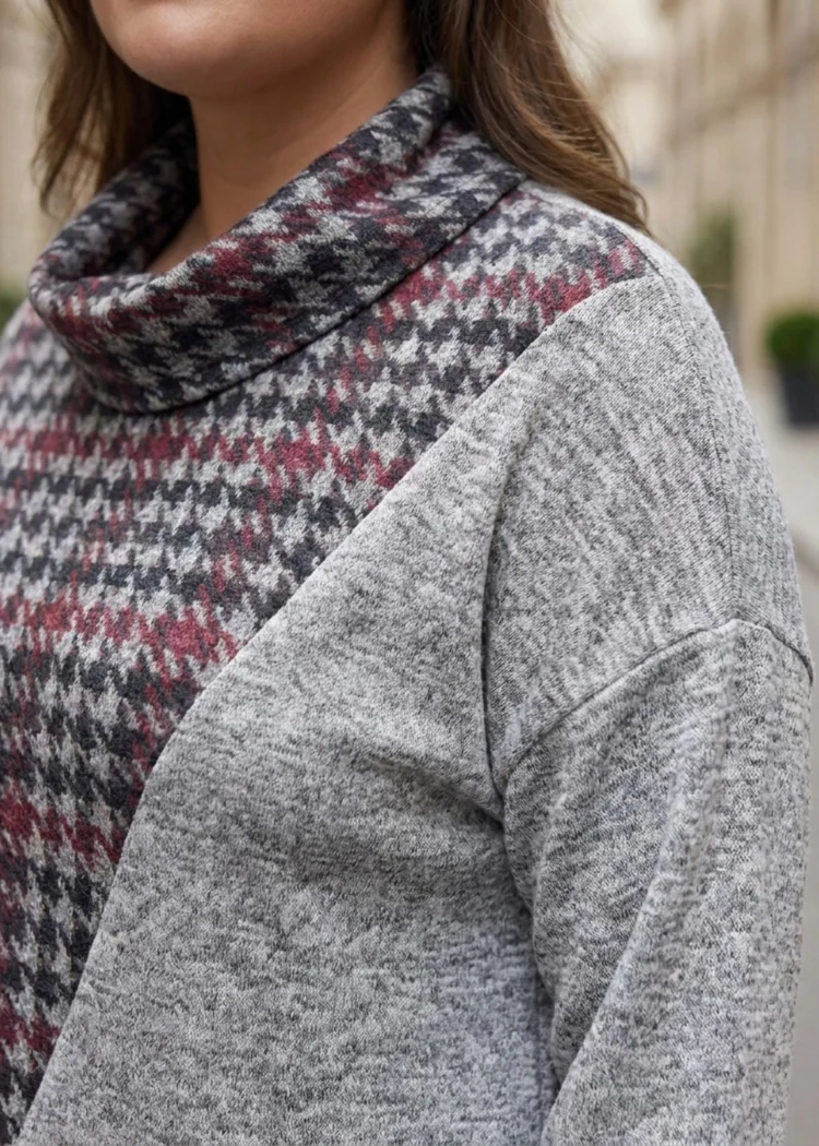 Sweter damski Bluzka sweterkowa z kominem w pepitkę, zbliżenie na dekolt i połączenie wzorów.