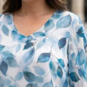 Tunika damska Elegancka dwuwarstwowa w niebieskie liście, detal dekoltu w serek i szerokiego rękawa.
